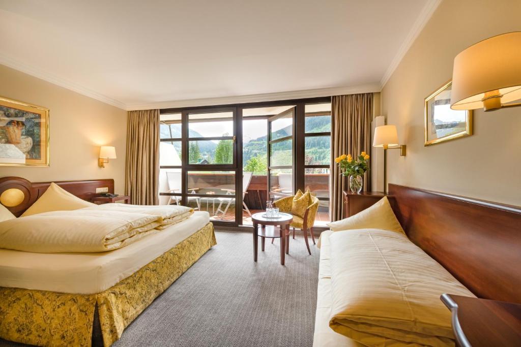 a hotel room with two beds and a couch at Familienhotel Sonngastein in Bad Gastein