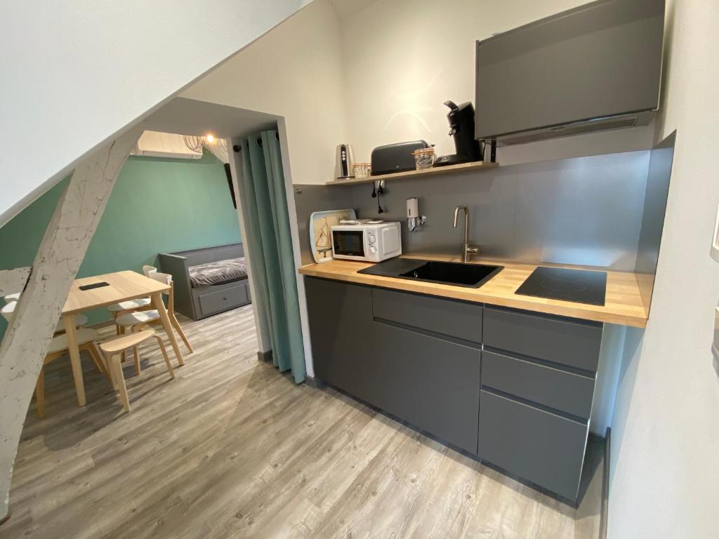 a kitchen with a sink and a table in a room at Logement Loire climatisé, La Halte de Cuze, aux abords de la Loire a vélo in Huismes