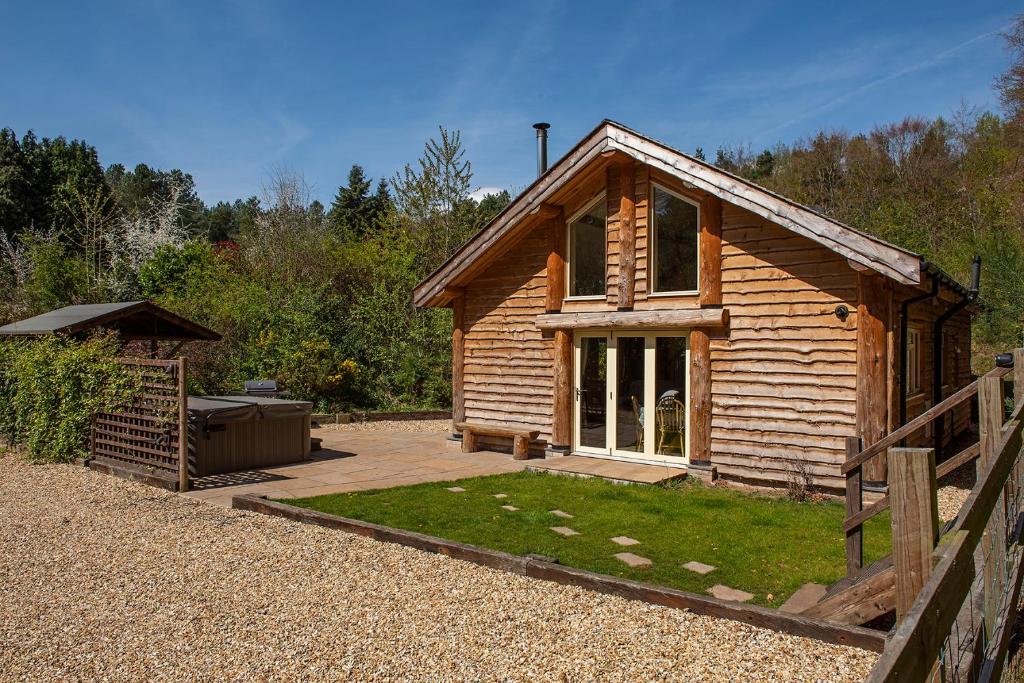 uma cabana de madeira com um quintal e uma cerca em Loxleys Lodge em Newark upon Trent