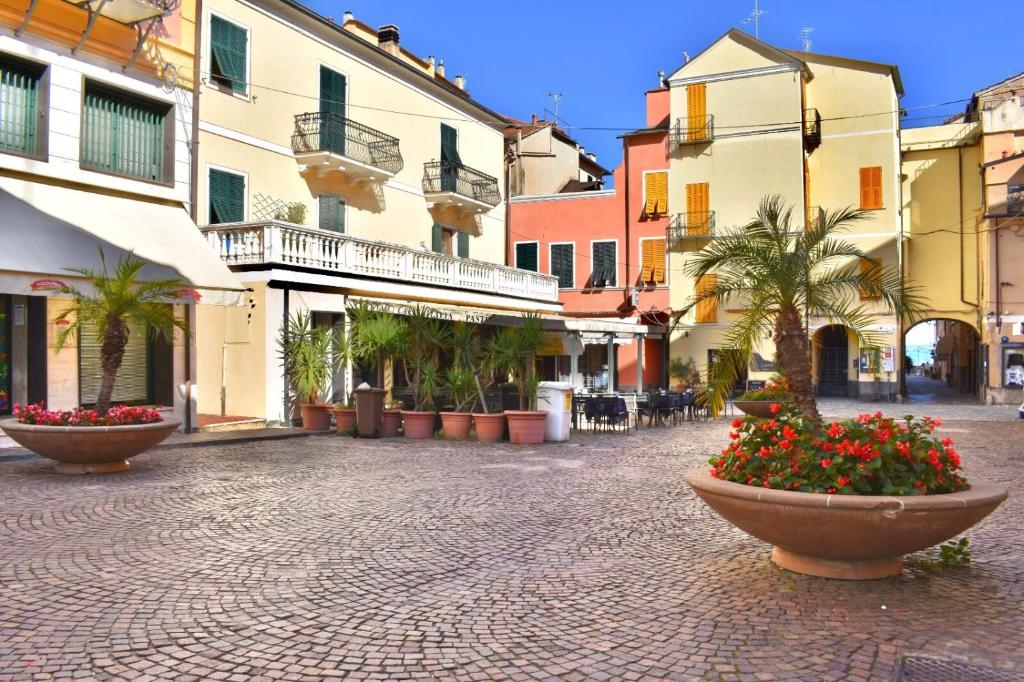 una strada di ciottoli con fiori all'interno degli edifici di La Stella Marina a Laigueglia