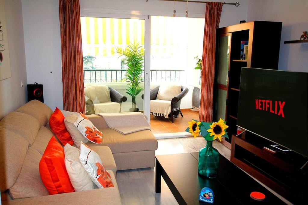 sala de estar con sofá y TV de pantalla plana en Gran Calahonda Beach near Marbella, en Málaga