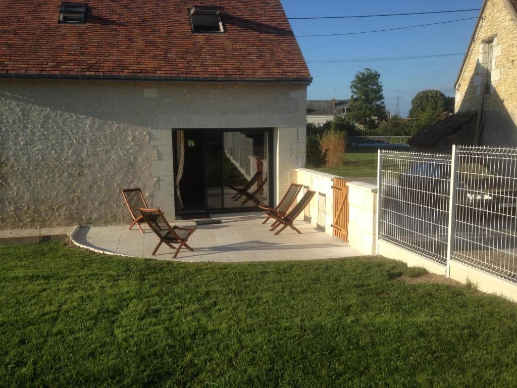 2 chaises assises sur une terrasse près d'une maison dans l'établissement La Grange de la Chaise, à Saint-Georges-sur-Cher