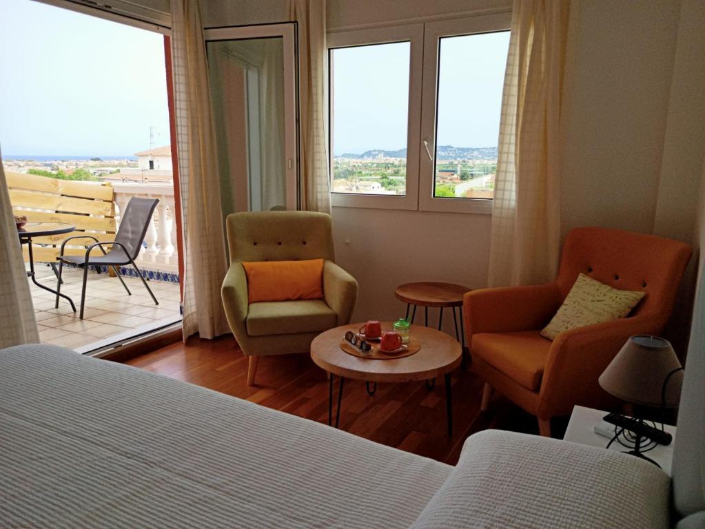 - une chambre avec un lit, deux chaises et une table dans l'établissement Casa Valentina, à Jávea
