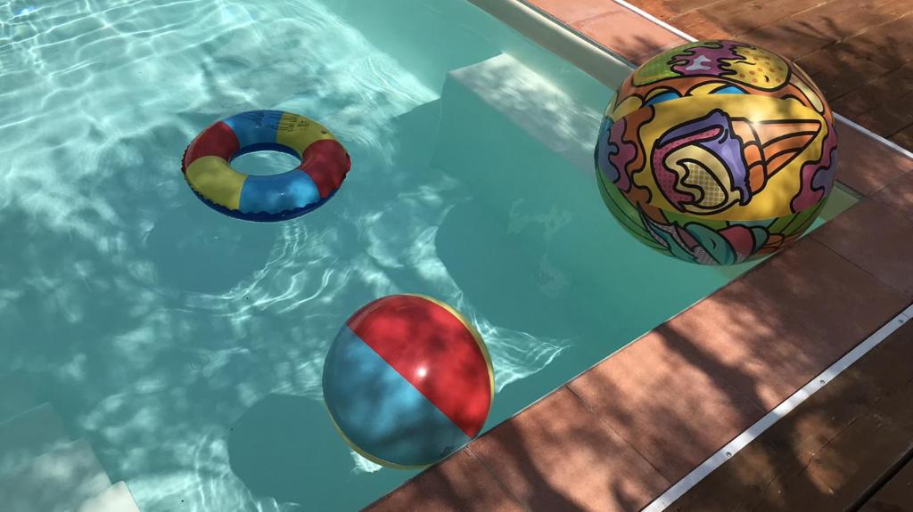 drei Strandbälle in einem Schwimmbad in der Unterkunft Villa Martina in Pietracuta