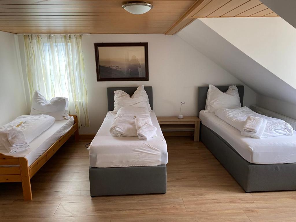 a room with two beds with white pillows at Dorfschenke in Siegen