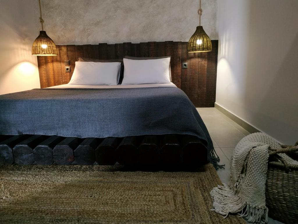 een slaapkamer met een groot bed met 2 kussens bij Aethrèa Apartments in Charaki