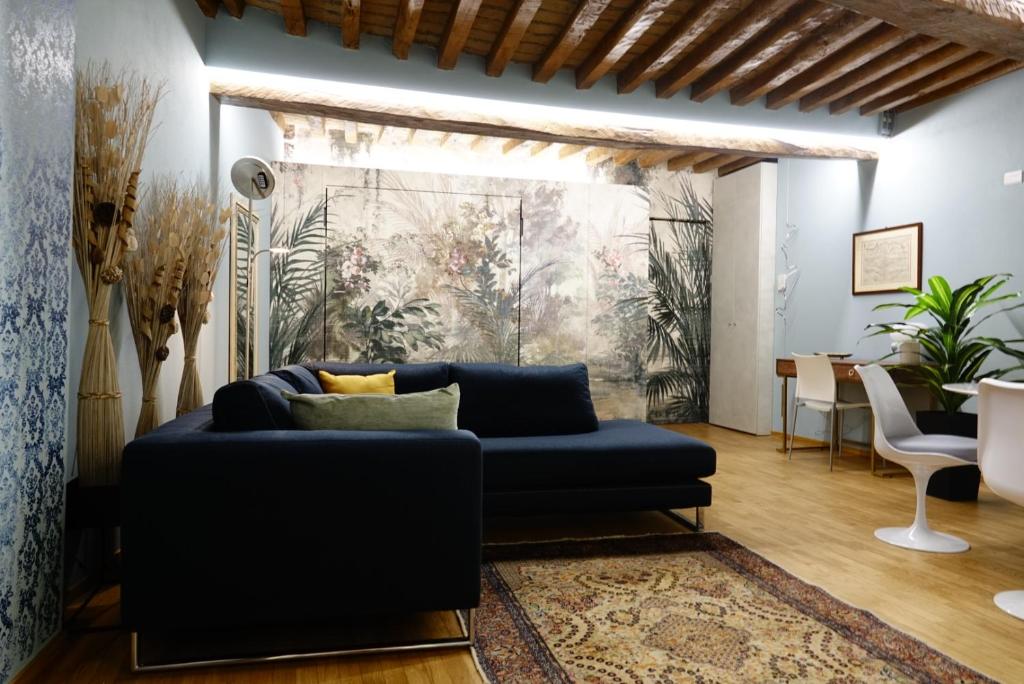 ein Wohnzimmer mit einem blauen Sofa und einem Tisch in der Unterkunft La dimora Blu in Parma