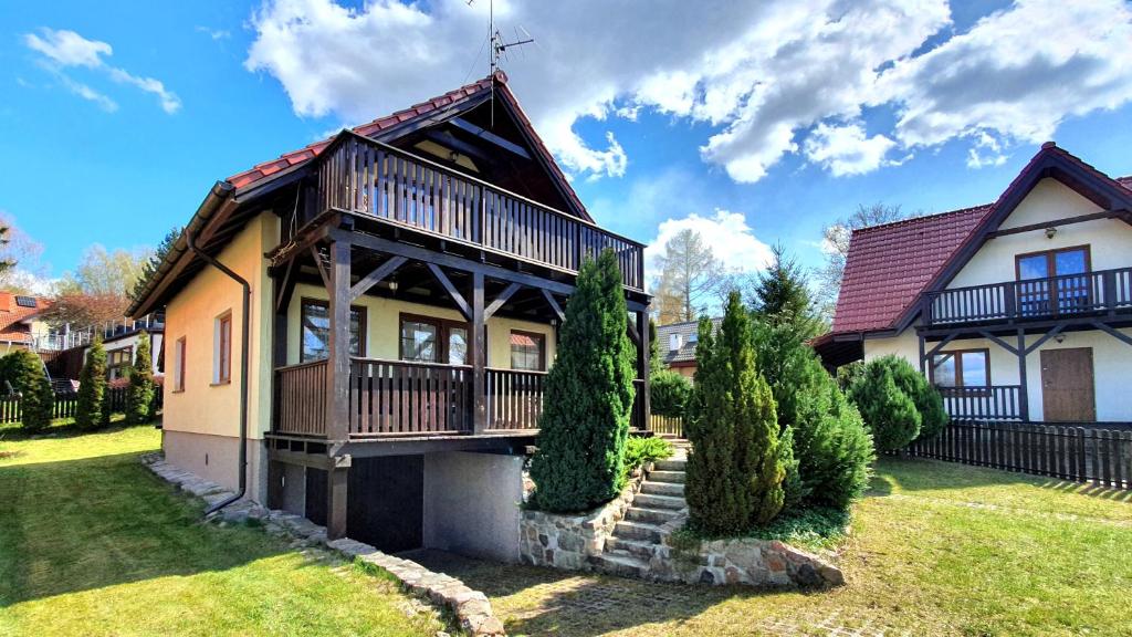 a house with a balcony on a yard at Dom letniskowy Narie in Morąg