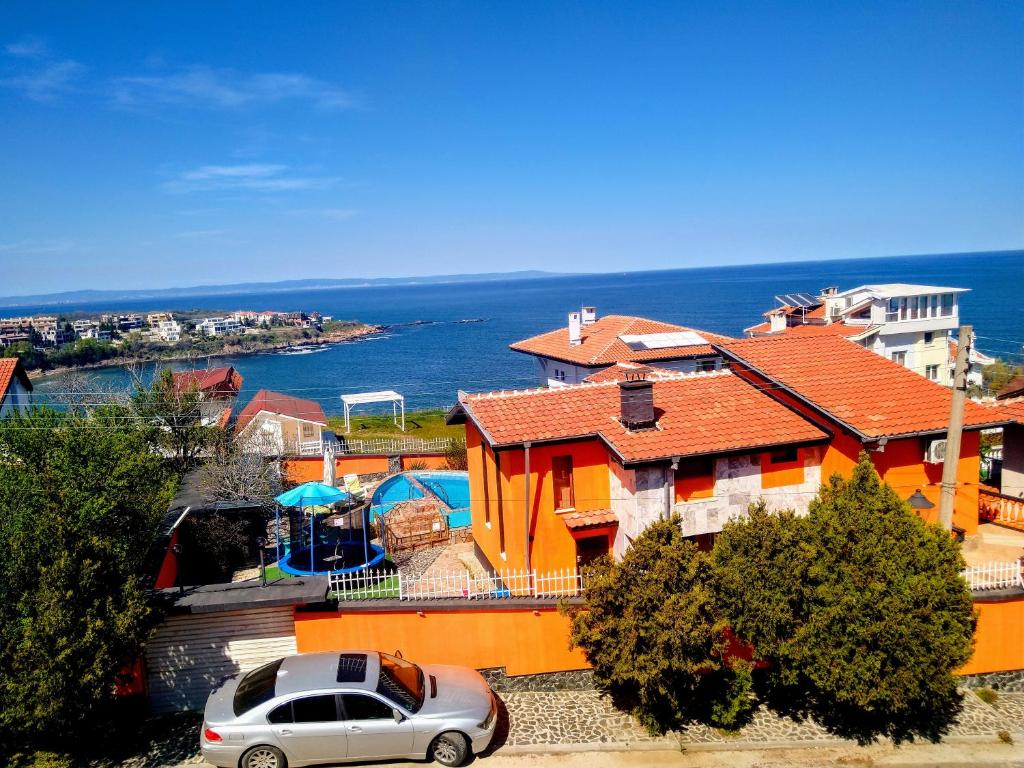 a car parked in front of a house next to the ocean at All inclusive luxury villa with sea view in Chernomorets