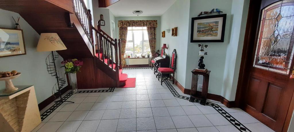 a hallway with a staircase with red chairs in a house at Creevagh (Room Only) in Keel