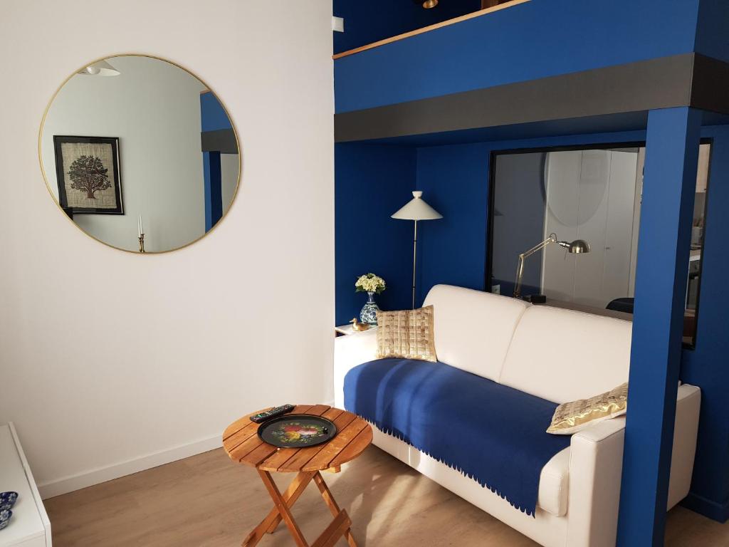 una camera da letto blu e bianca con letto e specchio di Brest : Beau T1 en centre ville a Brest