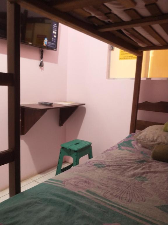 Guaraná da Cláudia في سانتاريم: غرفة نوم مع سرير ومقعد أخضر