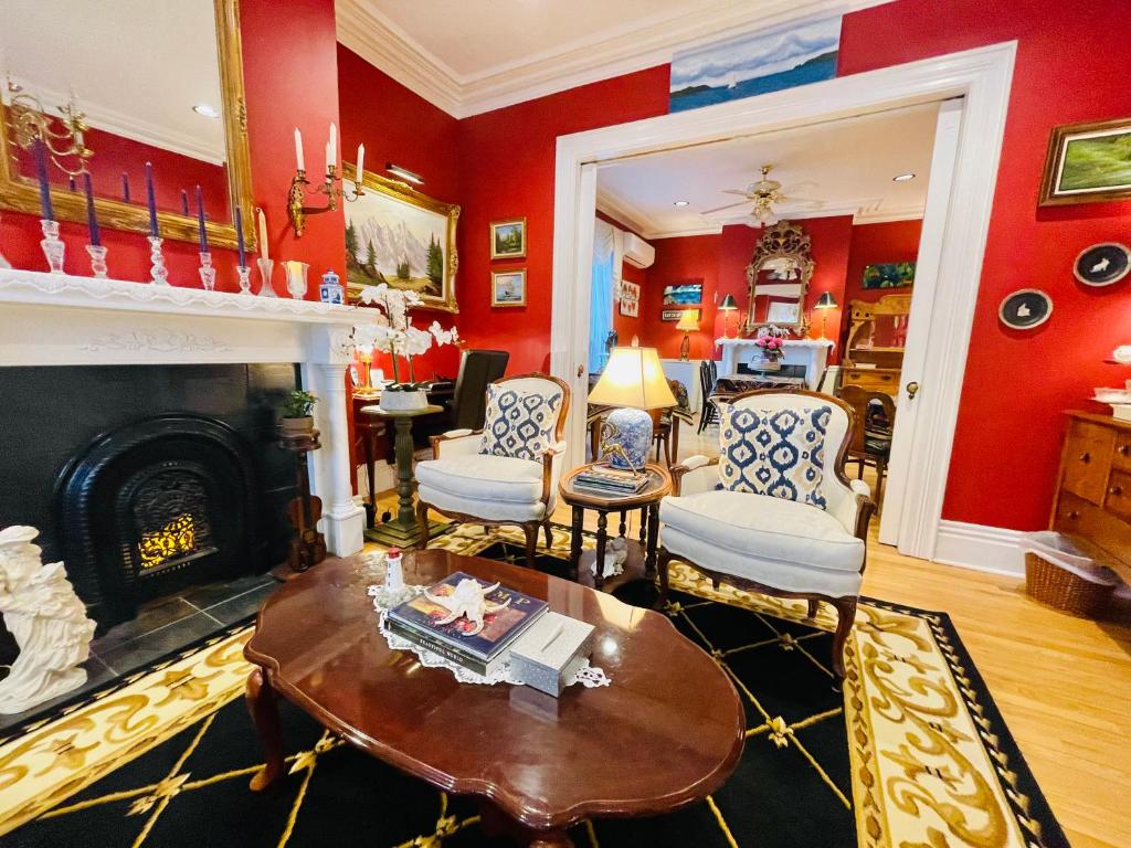 a living room with red walls and a fireplace at Charlotte's Rose Inn in Charlottetown