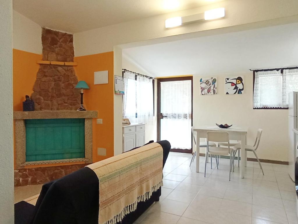 a living room with a fireplace and a table at Villa Milena Villasimius, WiFi gratuito, Ampio Giardino a 300 m dal Mare in Villasimius