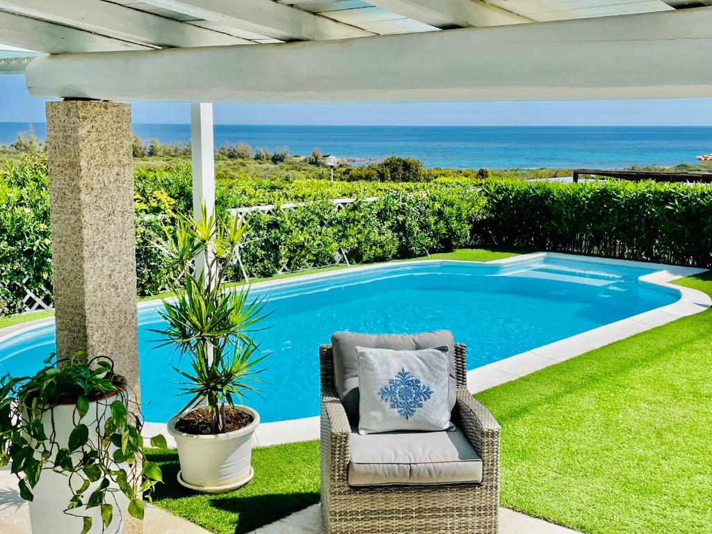une terrasse avec une chaise et une piscine dans l'établissement Villa Adel, à San Teodoro