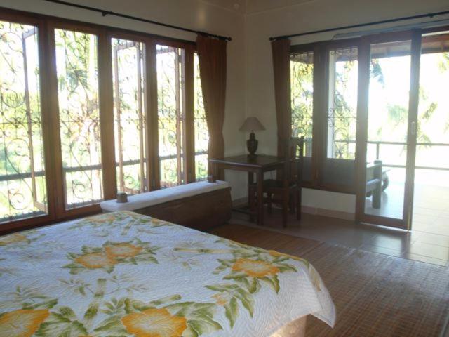 1 dormitorio con 1 cama con colcha de flores en Toko Toko Bungalows, en Ubud