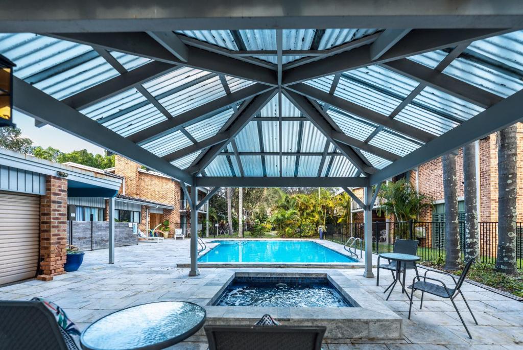 un patio con piscina y techo de cristal en The Select Inn Gosford, en Gosford