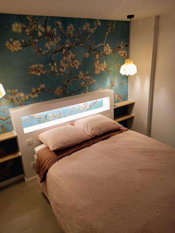 - une chambre avec un lit orné d'un mur fleuri dans l'établissement Superbe T2 avec grande terrasse en centre ville à 5 min à pieds des Arènes de Nîmes, à Nîmes