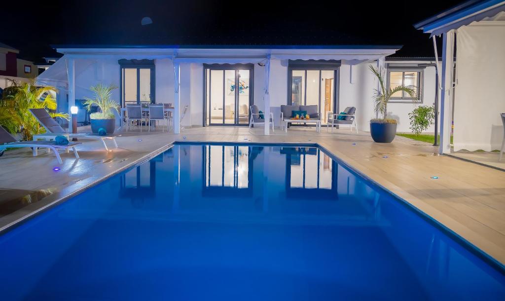 - une grande piscine d'eau bleue dans une maison dans l'établissement Ti Eden Villas a Saint-Francois, à Saint-François