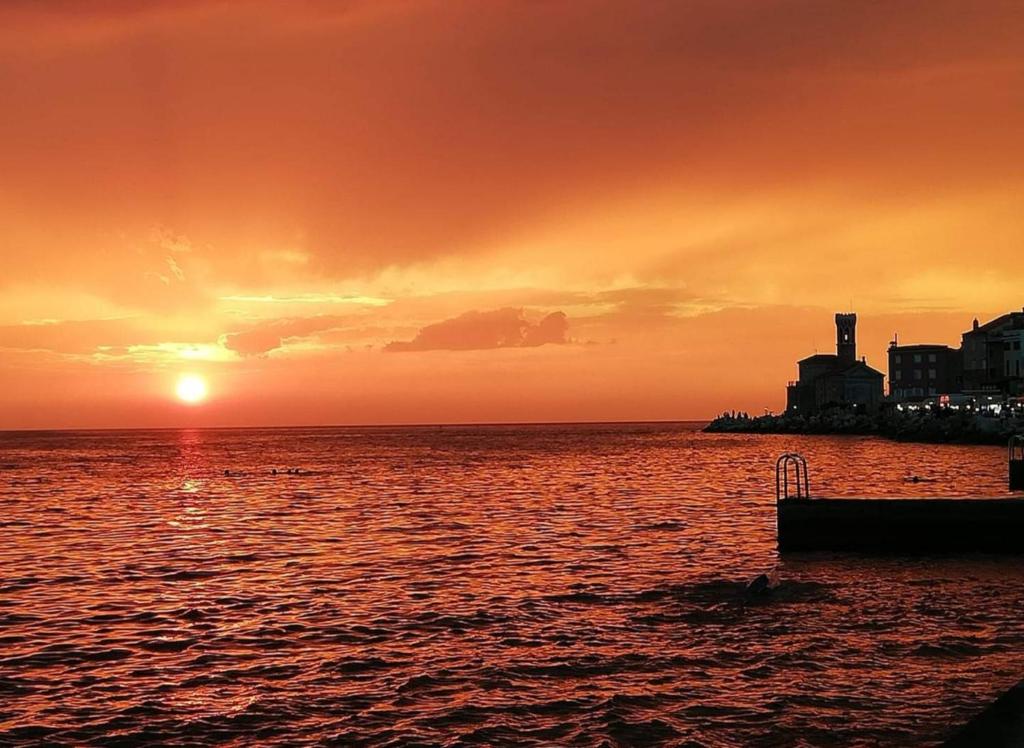 un coucher de soleil sur une grande étendue d'eau dans l'établissement Skipper, à Piran