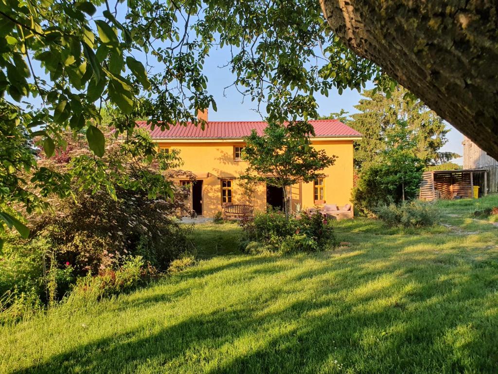 a yellow house with a red roof in a yard at Sonnenhügel in Neu Karin