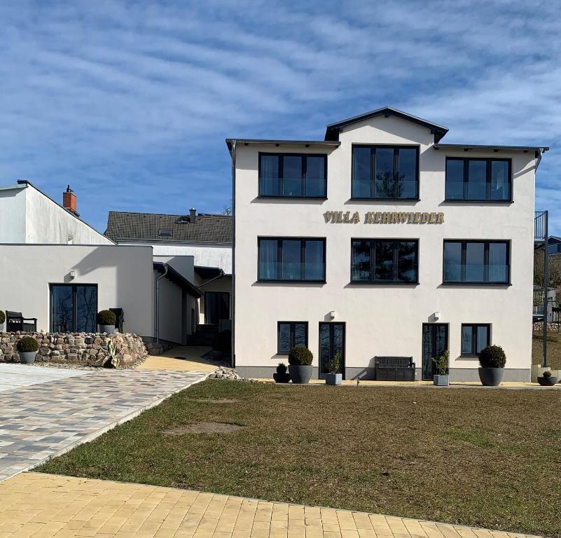 a white building with a sign on the front of it at Villa Kehrwieder in Göhren