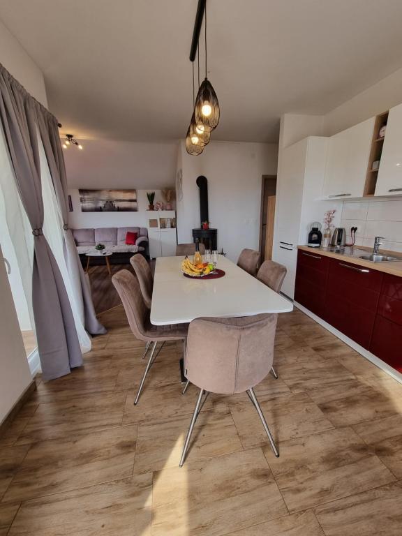 Il comprend une cuisine et une salle à manger avec une table et des chaises blanches. dans l'établissement Apartment Tena, à Privlaka