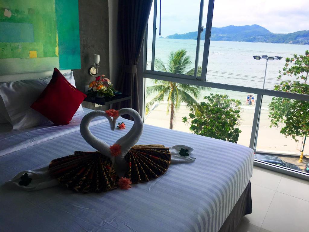 two swans in a dress sitting on a bed at The Front Hotel and Apartments in Patong Beach