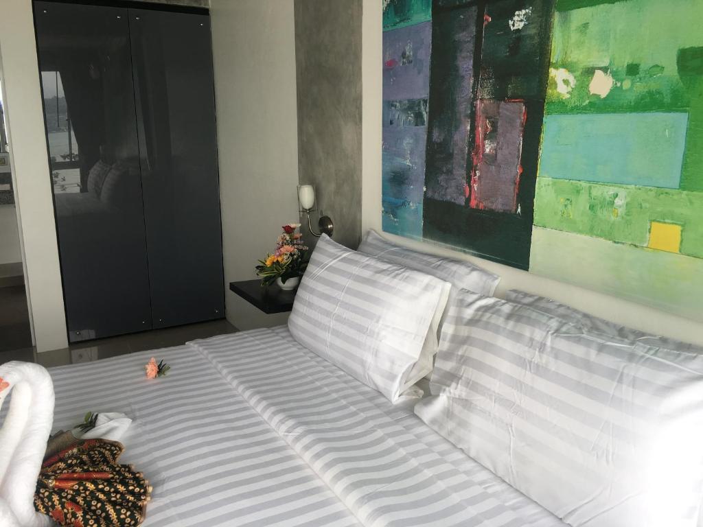 a white bed with white sheets and pillows in a bedroom at The Front Hotel and Apartments in Patong Beach
