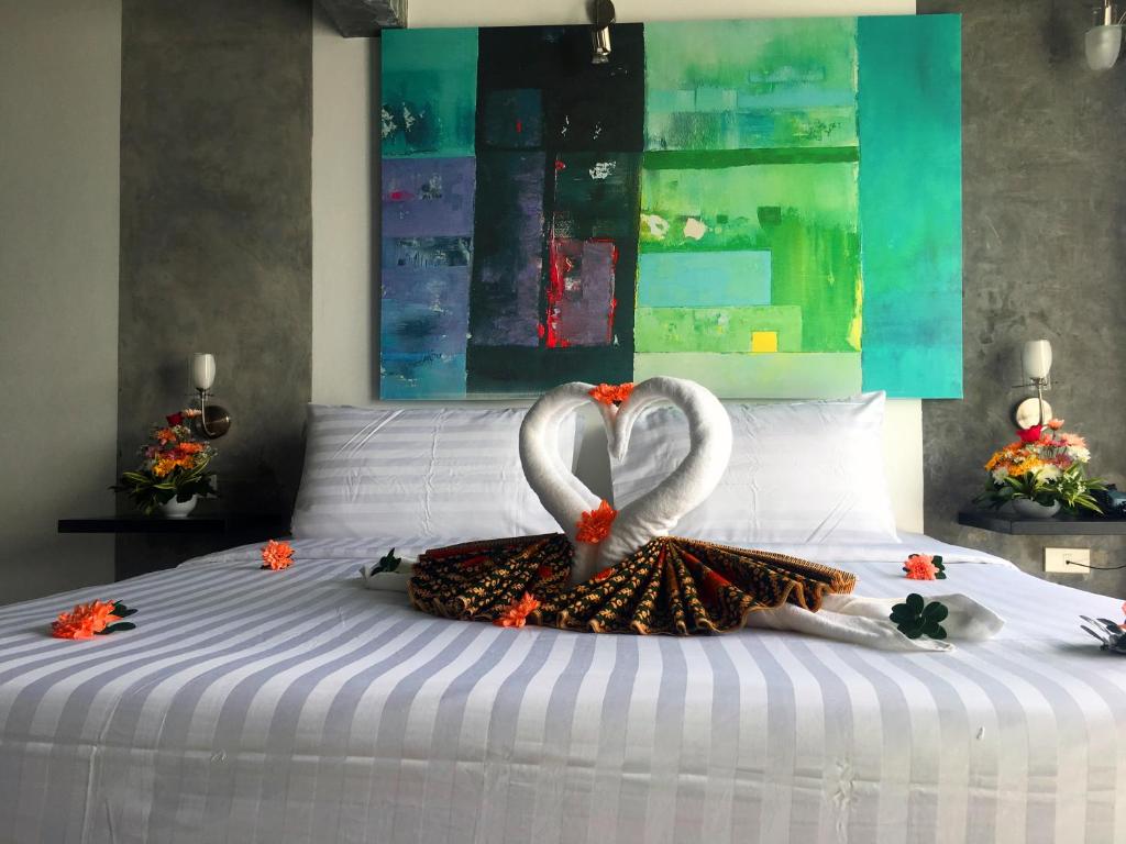 a bed with two swans made to look like hearts at The Front Hotel and Apartments in Patong Beach