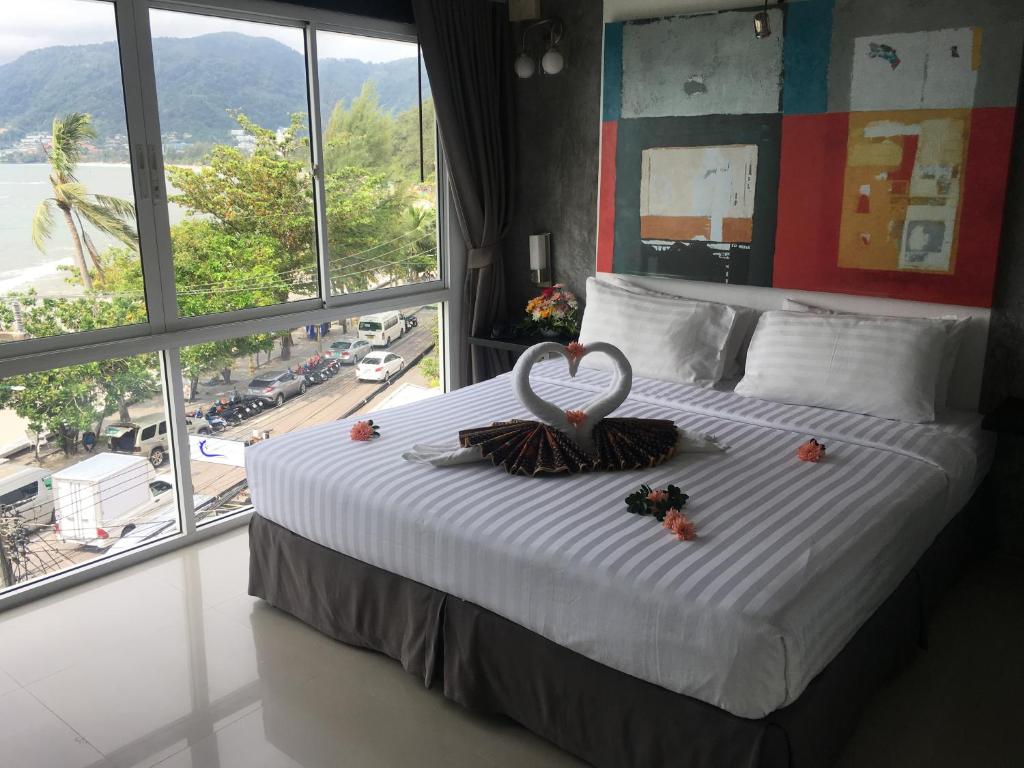a bedroom with a large bed with a wedding ring on it at The Front Hotel and Apartments in Patong Beach