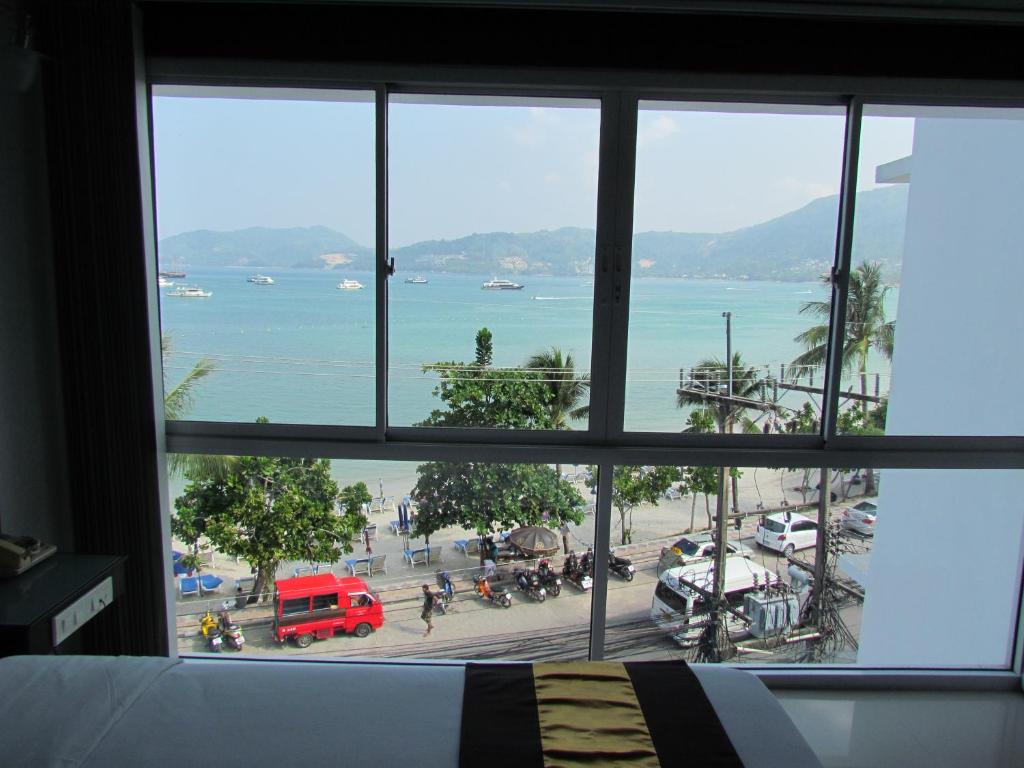 a view of the ocean from a bedroom window at The Front Hotel and Apartments in Patong Beach