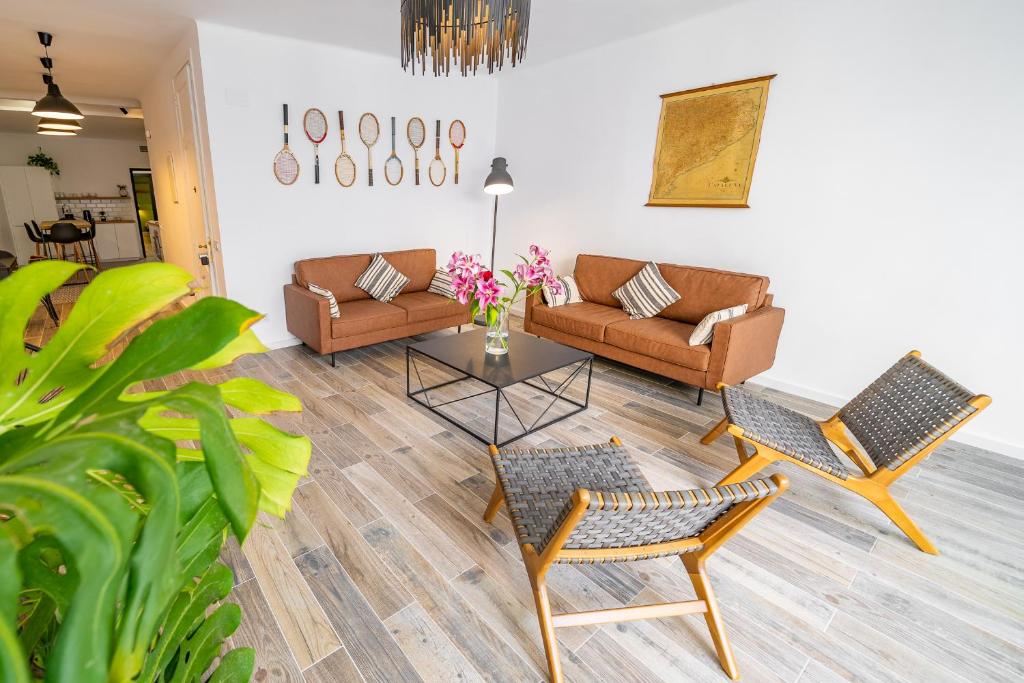 ein Wohnzimmer mit einem Sofa, Stühlen und einem Tisch in der Unterkunft CAN MARTINEZ Calella Beach Boutique Apartment in Calella