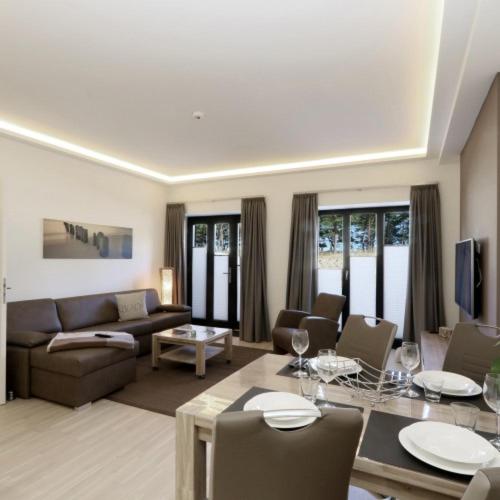 a living room with a couch and a table at Strand FeWo Rügen MoonLoft in Binz