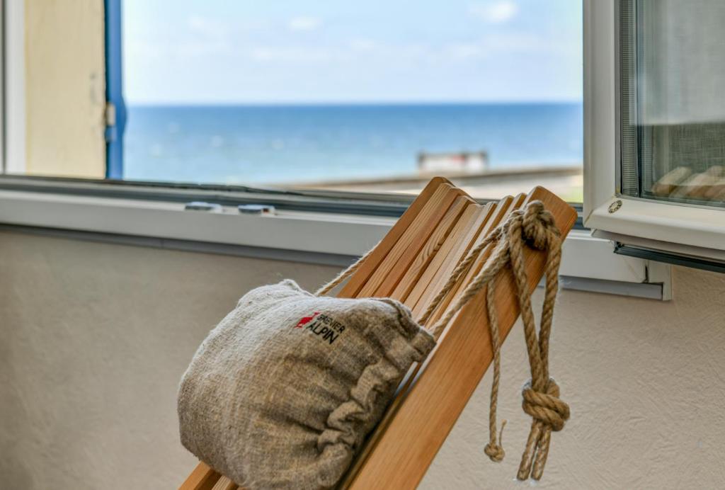 a hat sitting on a bench in front of a window at Logis Hotel de France in Mimizan-Plage
