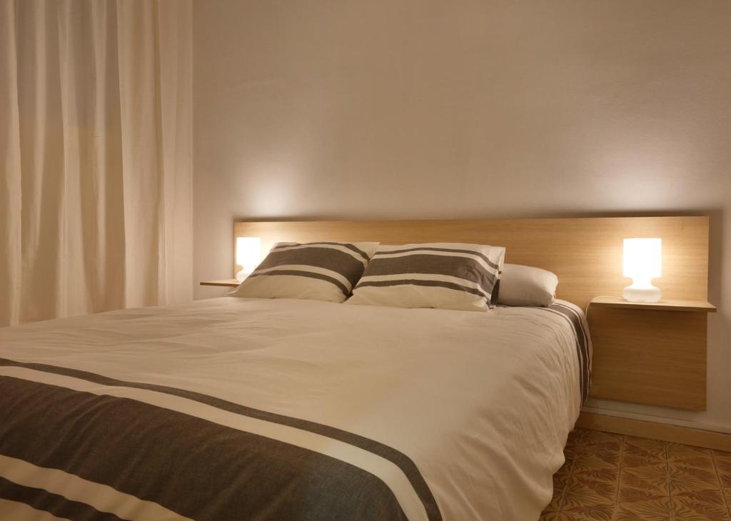 a bedroom with a large bed with two pillows at Apartaments Olivier Barcelona in Barcelona