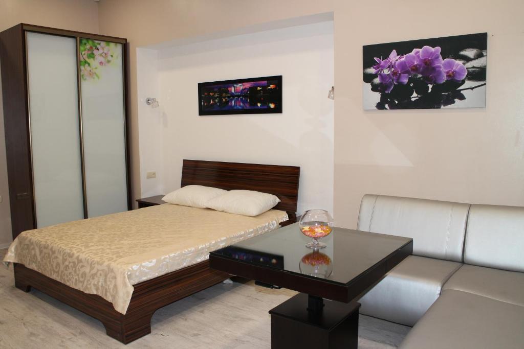 1 dormitorio con cama, mesa y sofá en Elite Odessa Apartments en Odesa