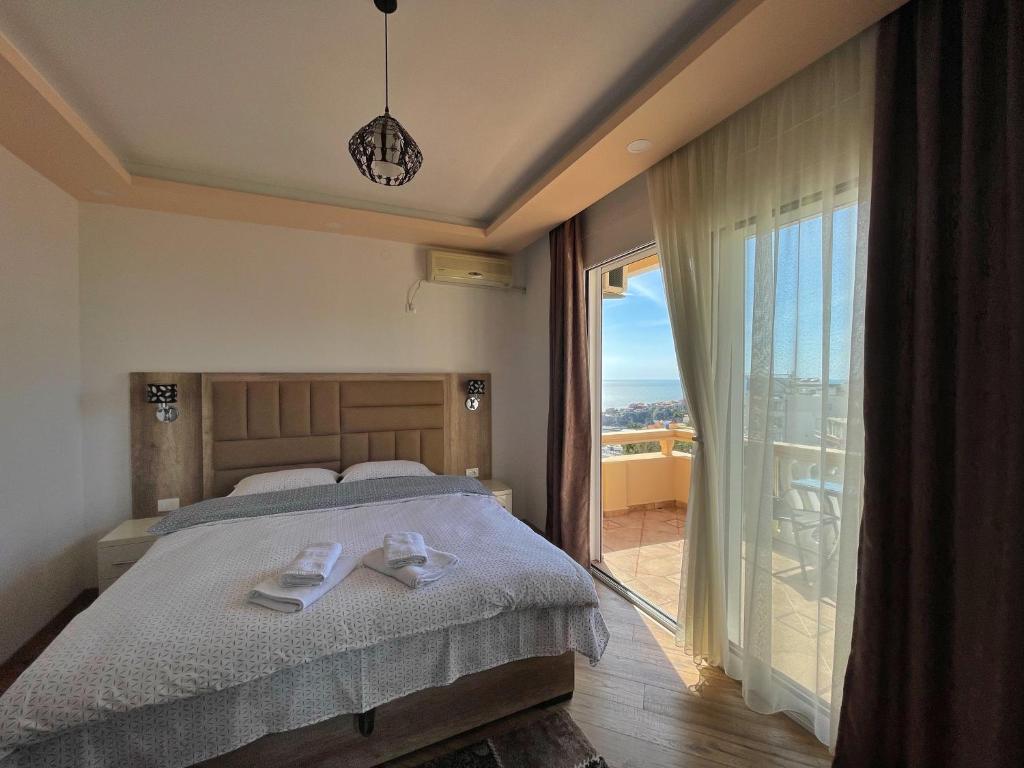 a bedroom with a bed and a large window at Apartments Albin in Ulcinj