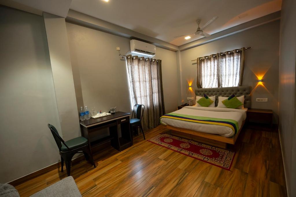 a bedroom with a bed and a desk and a table at HOTEL MITTAL GARDEN in Siliguri