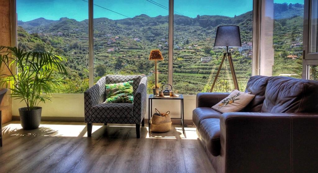 a living room with a couch and a large window at LA CHOZA VILLA VACACIONAL in Teror