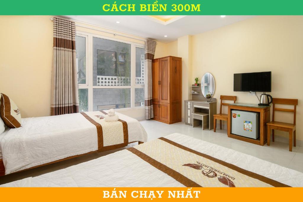Cette chambre comprend deux lits et une télévision. dans l'établissement Khách sạn Đàm Phúc Đà Nẵng, à Đà Nẵng