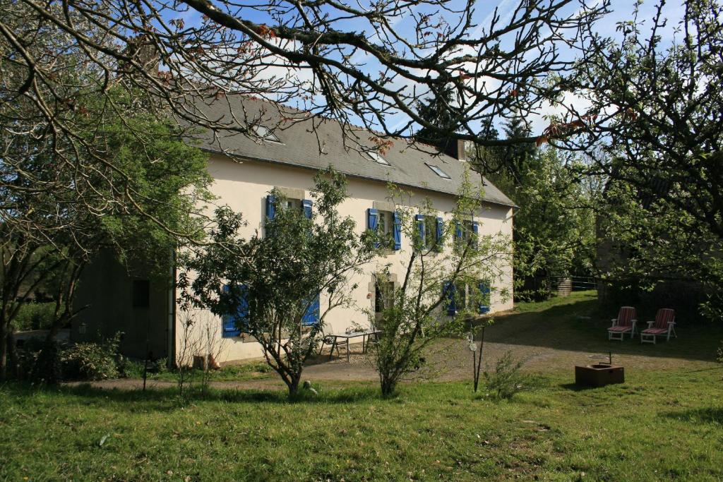 ein weißes Haus mit blauen Fenstern und einem Hof in der Unterkunft Kercapitaine in Bannalec