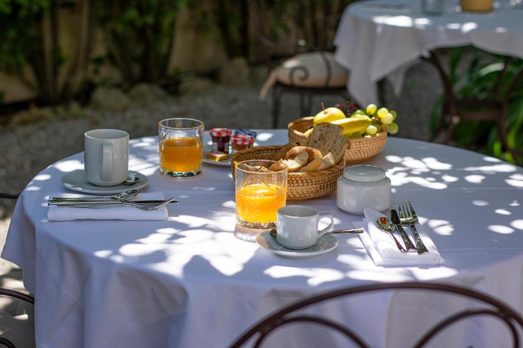 a white table with a basket of food and glasses of orange juice at Lou Cagnard in Saint-Tropez
