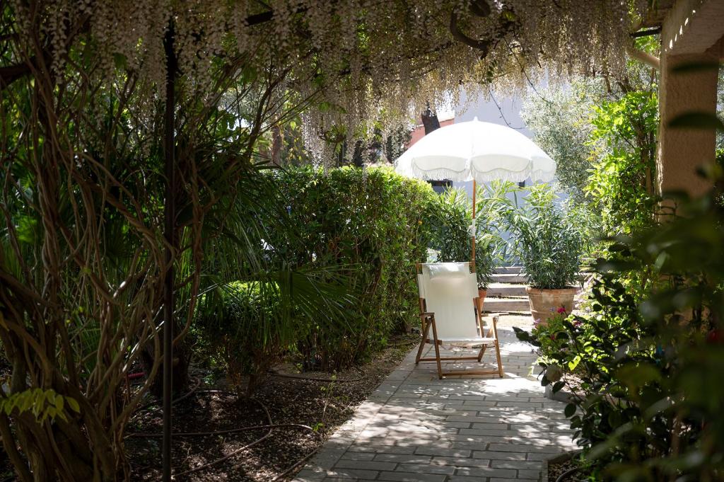 a chair and an umbrella in a garden at Lou Cagnard in Saint-Tropez