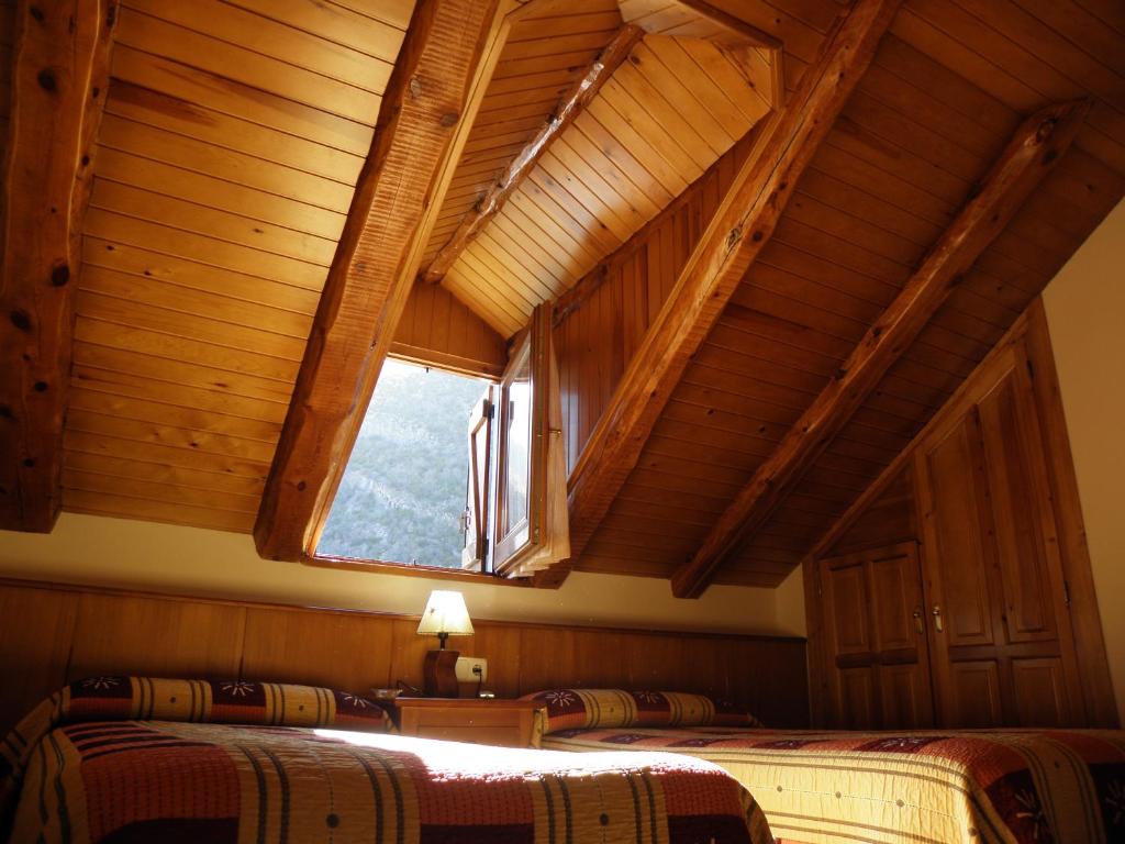 1 dormitorio con 2 camas y ventana en Casa Torellola en Cardet