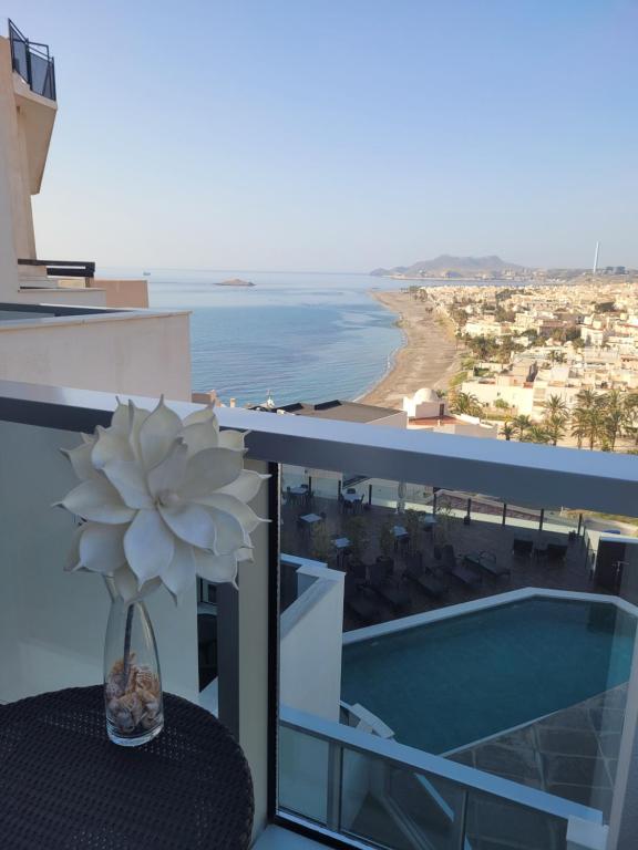 un jarrón con una flor sentado en una mesa en un balcón en Hotel Carboneras Cabo de Gata by MIJ en Carboneras