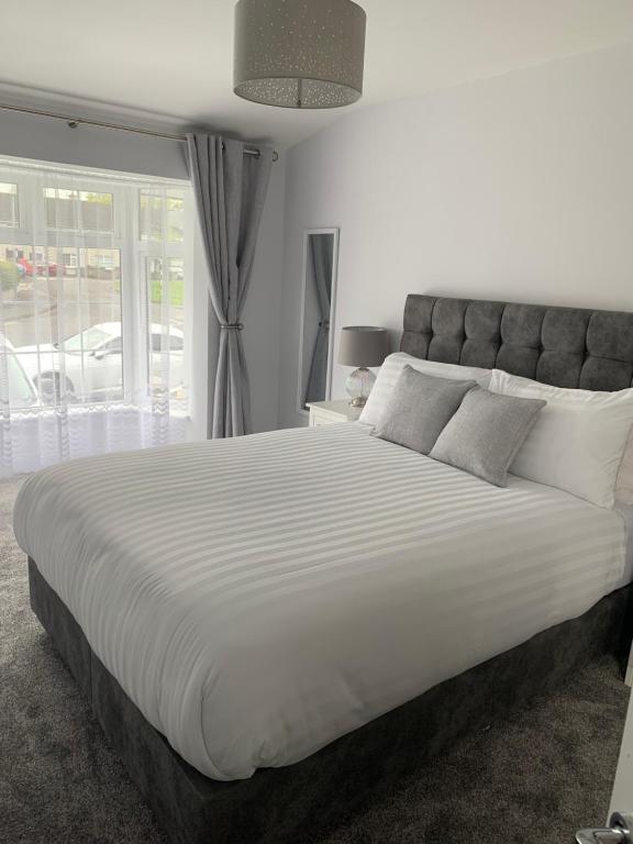 ein großes weißes Bett in einem Schlafzimmer mit Fenster in der Unterkunft Stonehaven in Kilkenny