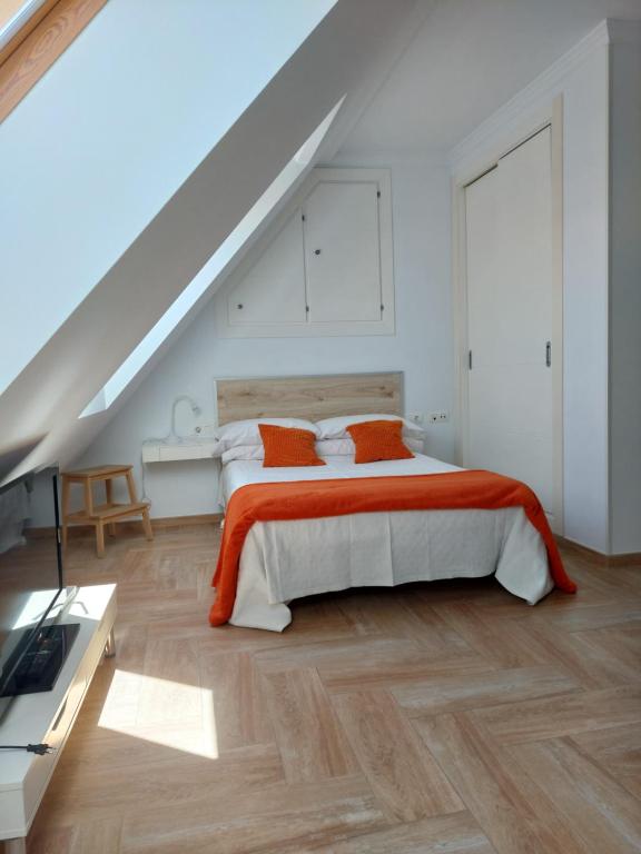 a bedroom with a bed with an orange blanket at Ático by Alhaurín Loft City Center in Alhaurín de la Torre