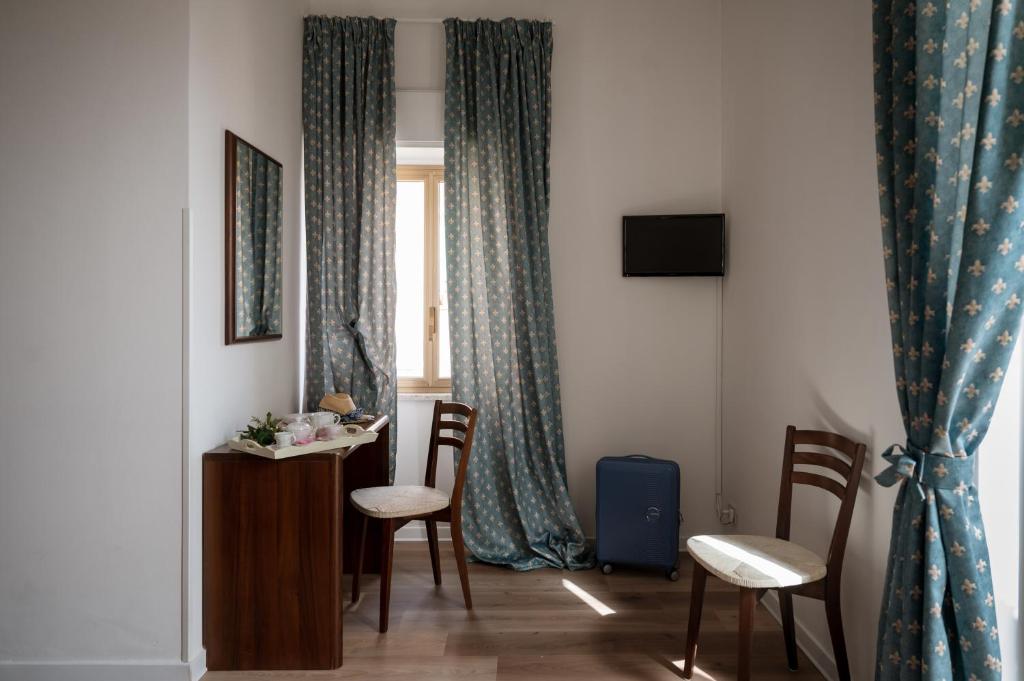 Pokój ze stołem, krzesłami i oknem w obiekcie Hotel Elios Tao w Taominie