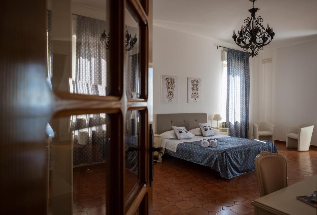 sypialnia z łóżkiem z niebieską narzutą w obiekcie Hotel Elios Tao w Taominie